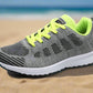 Grey and neon green women's breathable mesh sneakers, designed for optimal airflow and lightweight support. Perfect for running or casual outings with vibrant accents for style.