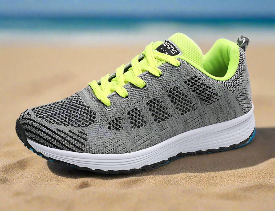 Grey and neon green women's breathable mesh sneakers, designed for optimal airflow and lightweight support. Perfect for running or casual outings with vibrant accents for style.