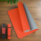 High-quality red yoga mat with a grey anti-slip back and a matching carrying case, offering durability and sweatproof design, ideal for yoga and fitness exercises.