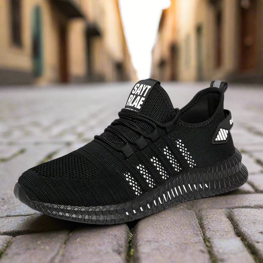 Black lightweight running sneakers with white accents, mesh upper, and textured sole for traction.Displayed on a cobblestone street for a sleek urban vibe.