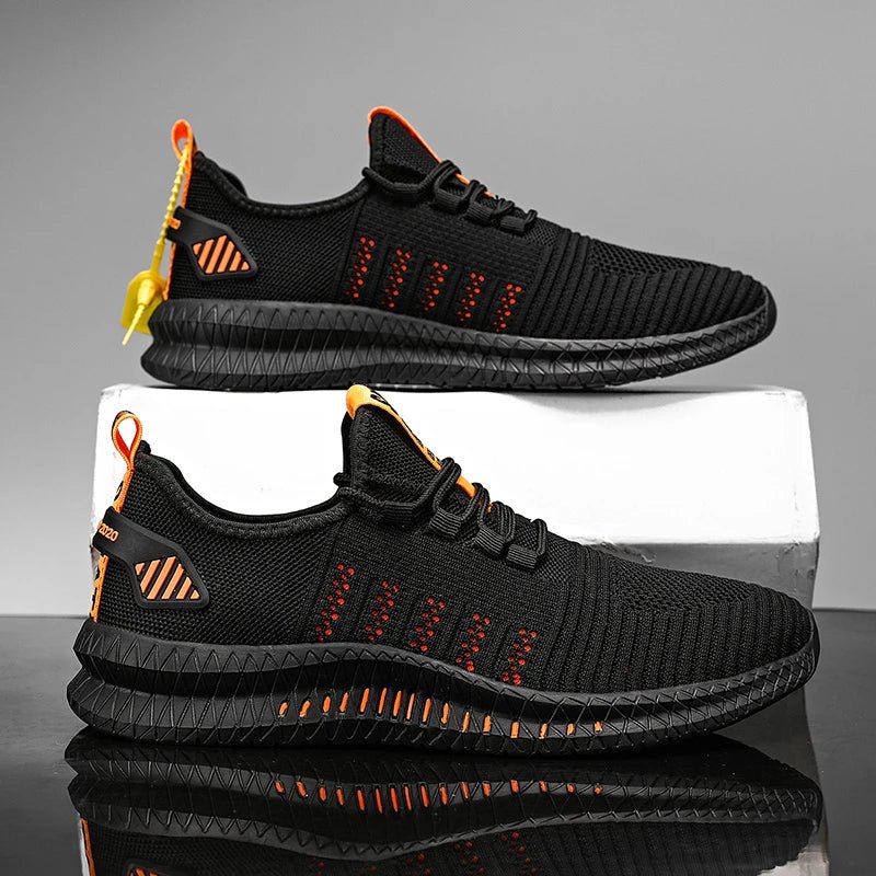 Side view of black and orange lightweight men's running shoes displayed on a white block, featuring breathable mesh fabric and cushioned soles for optimal comfort and performance.