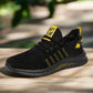 Black lightweight running shoe with yellow accents, breathable mesh upper, and durable textured sole, placed on a wooden surface with a blurred natural background.