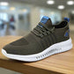 Olive green lightweight running shoe with a breathable mesh upper, white textured sole, and blue accents, placed on a wooden surface in a blurred indoor setting.