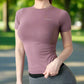 Women's short sleeve yoga shirt in soft pink, stretchy, form-fitting, and comfortable. Ideal for yoga or casual wear, offering flexibility and style for active lifestyles.